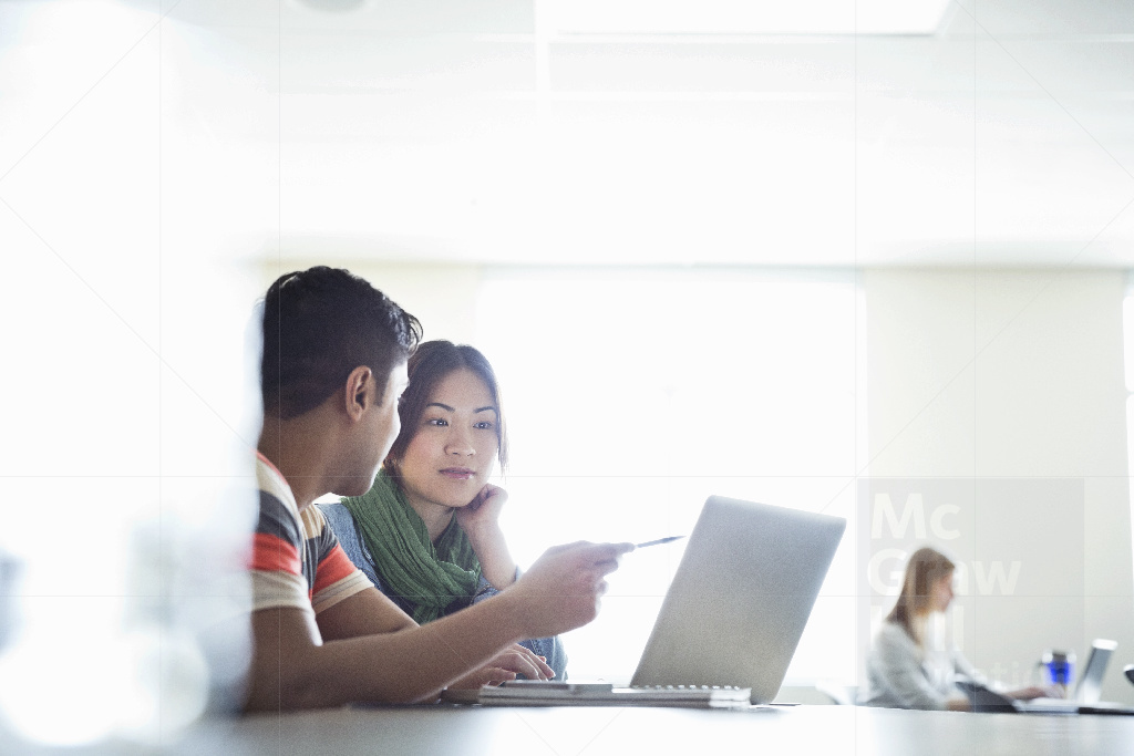 Indian Higher Education Student explaining to a Chinese student on laptop 